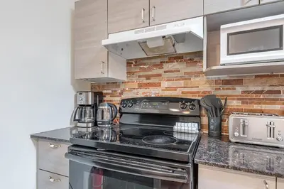 a kitchen with a stove and a brick wall at Elegant 3BR - High Ceilings & Vintage Charm in Montréal