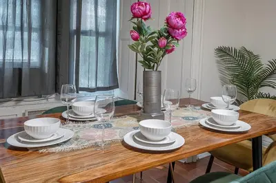 a dining room table with a vase of pink roses at Spacious 3BR Downtown - 2 Queen & Bunk & Sofa Bed in Montréal