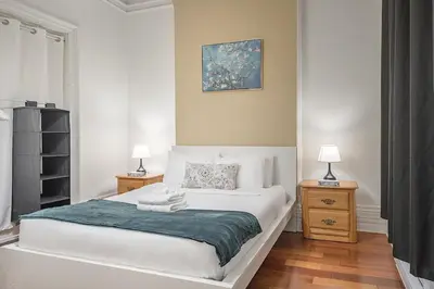 a bedroom with a bed with two night stands and two lamps at Spacious 3BR Downtown - 2 Queen & Bunk & Sofa Bed in Montréal