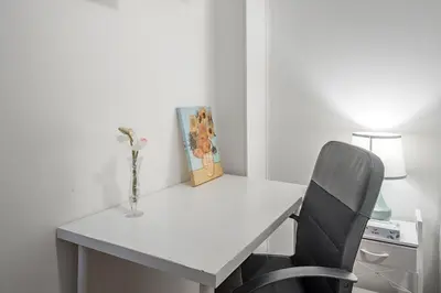 a white desk with a chair and a vase on it at Spacious 3BR Downtown - 2 Queen & Bunk & Sofa Bed in Montréal