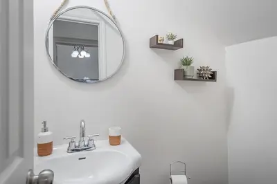 a bathroom with a sink and a mirror at Spacious 3BR Downtown - 2 Queen & Bunk & Sofa Bed in Montréal