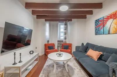 a living room with a blue couch and a table at Spacious 2BR Downtown - Vintage Charm Sleeps 10 in Montréal