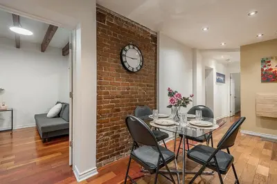 a dining room with a brick wall and a table and chairs at Spacious 2BR Downtown - Vintage Charm Sleeps 10 in Montréal