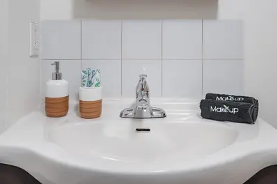 a white sink with two bottles and a faucet at Spacious 2BR Downtown - Vintage Charm Sleeps 10 in Montréal