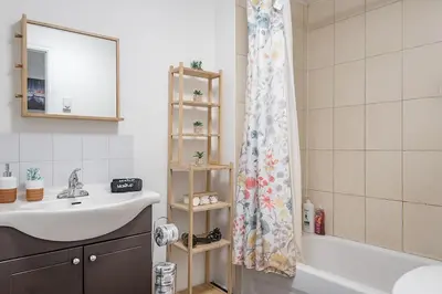 a bathroom with a sink and a shower curtain at Spacious 2BR Downtown - Vintage Charm Sleeps 10 in Montréal