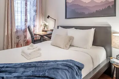 a bedroom with a large white bed with a desk at Spacious 2BR Downtown - Vintage Charm Sleeps 10 in Montréal