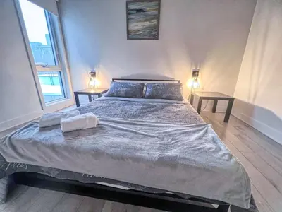 a large bed in a bedroom with two tables at Downtown Elite Residences in Montréal