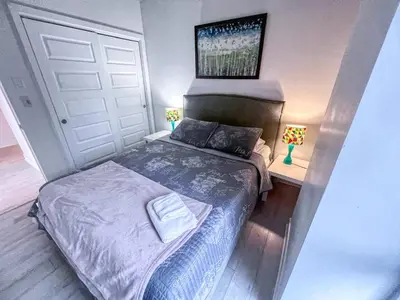 a small bedroom with a bed and two lamps at Downtown Elite Residences in Montréal