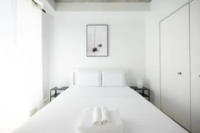 a bedroom with a white bed with two towels on it at Charming 1BR Old Port - Sofa Bed - Balcony with City View in Montréal