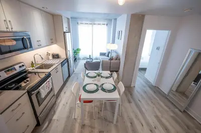 a kitchen and living room with a table in a kitchen at Charming 1BR Old Port - Sofa Bed - Balcony with City View in Montréal