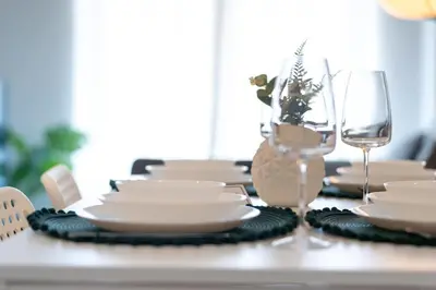 a table with white plates and a glass of wine at Charming 1BR Old Port - Sofa Bed - Balcony with City View in Montréal