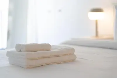 two towels sitting on top of a white bed at Spacious Apartment in Old Port Montreal in Montréal