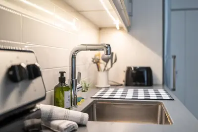 a kitchen with a sink with a bottle of wine at Spacious Apartment in Old Port Montreal in Montréal