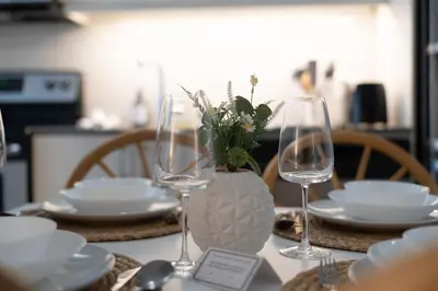 a table with glasses and plates and a vase with flowers at Spacious Apartment in Old Port Montreal in Montréal