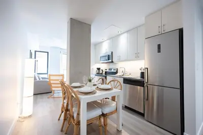 a kitchen with a white table and a white refrigerator at Spacious Apartment in Old Port Montreal in Montréal