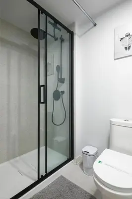 a bathroom with a glass shower with a toilet at Chic Hideaway - Downtown Hotspot in Montréal