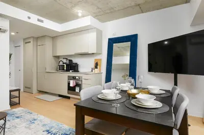 a dining room with a table with chairs and a television at Chic Hideaway - Downtown Hotspot in Montréal