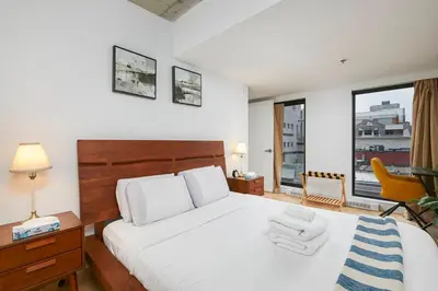 a bedroom with a bed and a desk and a chair at Chic Hideaway - Downtown Hotspot in Montréal