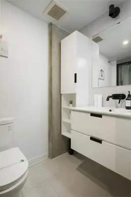 a white bathroom with a toilet and a sink at Chic Hideaway - Downtown Hotspot in Montréal