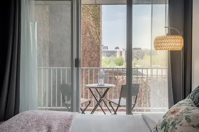 a bedroom with a bed and a balcony with a table at Urban Hideout - Downtown Haven in Montréal