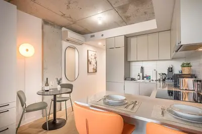 a kitchen with a table and chairs in a room at Urban Hideout - Downtown Haven in Montréal
