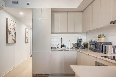 a kitchen with white cabinets and stainless steel appliances at Urban Hideout - Downtown Haven in Montréal