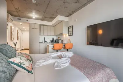 a living room with a white couch and a kitchen at Urban Hideout - Downtown Haven in Montréal