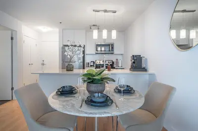 a dining room with a table and chairs and a kitchen at Old Port Upscale - Free Indoor Parking in Montréal