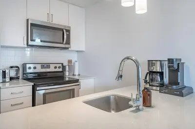 a kitchen with a sink and a microwave at Old Port Upscale - Free Indoor Parking in Montréal