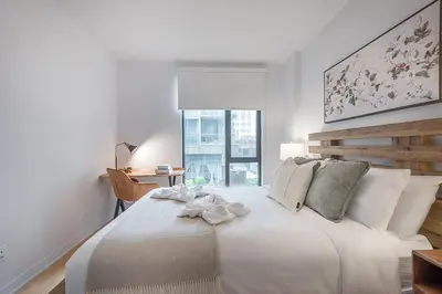 a white bedroom with a large bed and a window at Old Port Upscale - Free Indoor Parking in Montréal