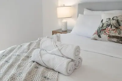 a bedroom with a white bed with towels on it at Corner 2BR Old Port - Free Indoor Parking in Montréal