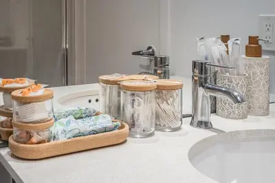 a bathroom counter with jars and a sink at Corner 2BR Old Port - Free Indoor Parking in Montréal