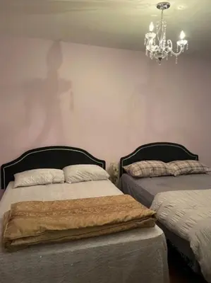 a bedroom with two beds and a chandelier at 2 Beds availabe and self service small breakfast in Montréal