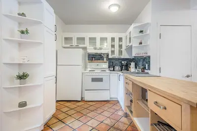 a kitchen with white cabinets and a wooden counter top at Stylish Loft Retreat - Prime Location - Sleeps 8 in Montréal