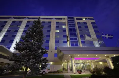 a building with a christmas tree in front of it at Armon Plaza Montreal Airport in Saint-Laurent