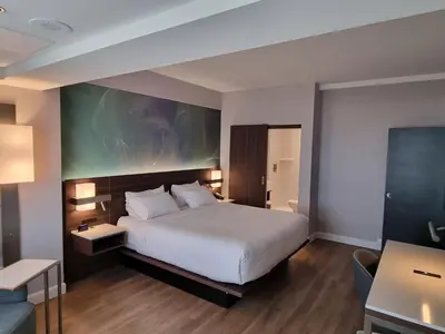 a hotel room with a bed and a desk at Armon Plaza Montreal Airport in Saint-Laurent