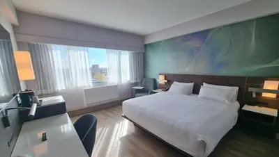 a bedroom with a bed and a large painting on the wall at Armon Plaza Montreal Airport in Saint-Laurent
