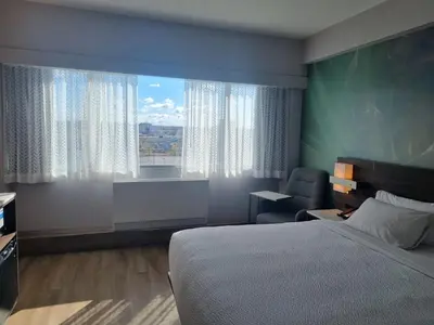 a hotel room with a bed and a window at Armon Plaza Montreal Airport in Saint-Laurent