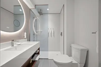 a bathroom with a toilet and a sink and a shower at Armon Plaza Montreal Airport in Saint-Laurent