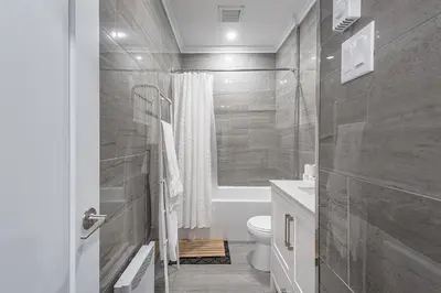 a bathroom with a shower and a toilet and a sink at Modern 2BR - 2 Full Bathrooms - Trendy Griffintown in Montréal