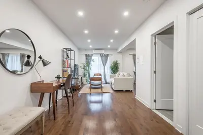 a living room with a table and a mirror at Modern 2BR - 2 Full Bathrooms - Trendy Griffintown in Montréal