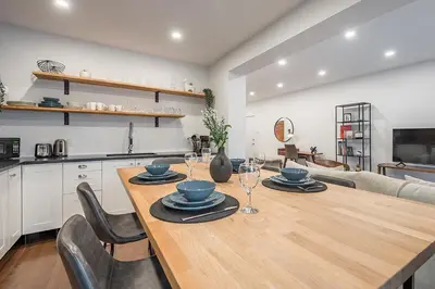 a kitchen and dining room with a wooden table and chairs at Modern 2BR - 2 Full Bathrooms - Trendy Griffintown in Montréal