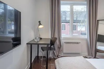 a room with a desk and a bed and a window at Modern 2BR - 2 Full Bathrooms - Trendy Griffintown in Montréal