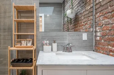 a bathroom with a sink and a brick wall at Modern 2BR - 2 Full Bathrooms - Trendy Griffintown in Montréal