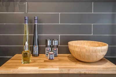 a wooden table with bottles and a bowl on it at Modern 2BR - 2 Full Bathrooms - Trendy Location in Montréal