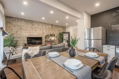 a kitchen and dining room with tables and chairs at Modern 2BR - 2 Full Bathrooms - Trendy Location in Montréal