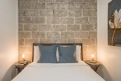 a bedroom with a brick wall and a bed with pillows at Modern 2BR - 2 Full Bathrooms - Trendy Location in Montréal