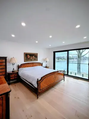 a bedroom with a large bed and a large window at Maison prestige sur la rive in Laval