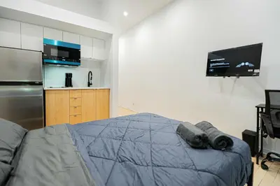 a bedroom with a bed and a refrigerator and a tv at Great apartment with parking in Montréal