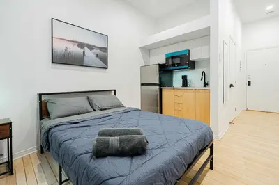 a bedroom with a bed and a kitchen at Great apartment with parking in Montréal